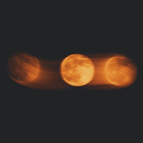 Three amber moons against a dark sky