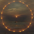A ring of amber light over the sea at dusk