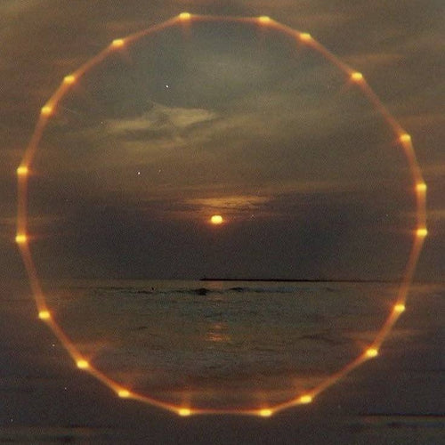 A ring of amber light over the sea at dusk
